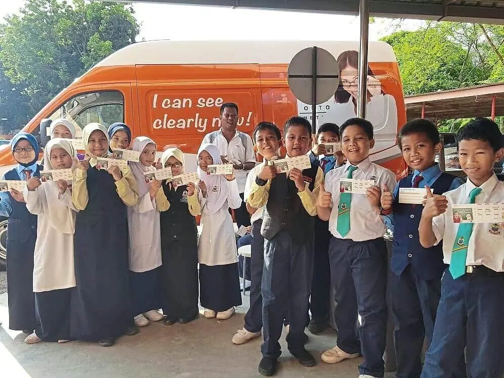 Clear view of the future: Schoolchildren holding vouchers for free eye check-ups and spectacles provided by the Eyecon mobile team.
